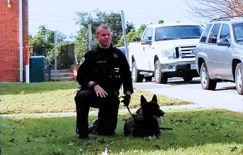 Police Officer Kneeling With Dog